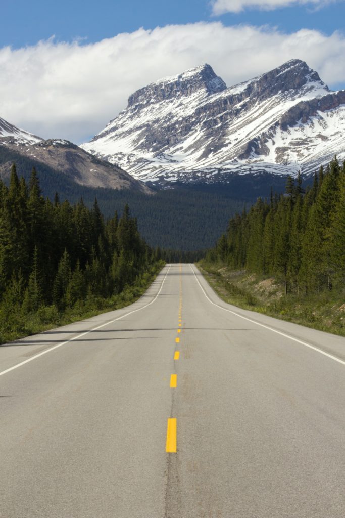 open road leading to snowy mountains
